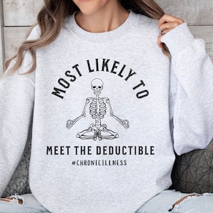 May include: Gray sweatshirt with a skeleton meditating and the text "Most Likely To Meet The Deductible #ChronicIllness"