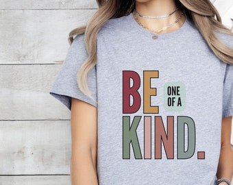 May include: A gray t-shirt with the text "BE ONE OF A KIND." in colorful block letters. The letters are in shades of red, orange, green, pink, and gray.