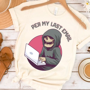 May include: A white t-shirt with a graphic of a skeleton wearing a hooded robe and using a laptop. The text "Per My Last Email" is above the graphic.