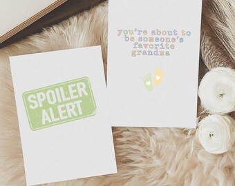 Puede incluir: Dos tarjetas de felicitación blancas. Una tarjeta tiene el texto "SPOILER ALERT" en verde, con una fuente desgastada. La otra tarjeta tiene el texto "you're about to be someone's favorite grandma" en colores pastel, con iconos de pies de bebé.