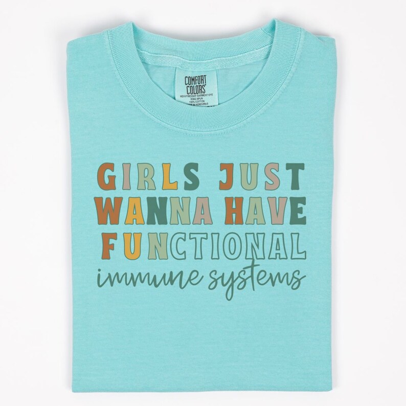 May include: A light blue t-shirt with the text "Girls Just Wanna Have Functional Immune Systems" in colorful letters.