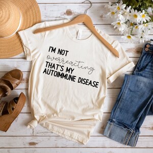 May include: A beige t-shirt with black text that reads "I'm not overreacting that's my autoimmune disease".