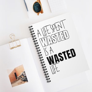 May include: A white spiral notebook with black text that reads "A life spent wasted is a wasted life".