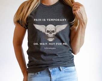 Puede incluir: Una camiseta gris oscuro con un gráfico de calavera y alas blancas. El texto en la camiseta dice "El dolor es temporal. Oh, espera. No para mí. #chronicpain"