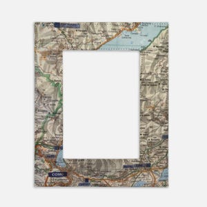 May include: Rectangular photo frame featuring a vintage map design. The frame's border is a detailed map with various place names and roads. The map's color palette includes beige, brown, and orange, creating a classic, aged aesthetic. The frame has a large, empty rectangular space in the center.
