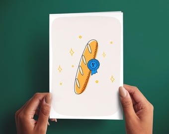 Könnte beinhalten: Eine Grußkarte mit einer zentralen Illustration eines goldbraunen Baguettes, das mit einer blauen Erstplatzierungsschleife verziert ist. Der Hintergrund ist in einem sanften Cremeton gehalten und mit kleinen gelben Sternen verziert.