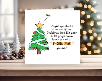 Könnte beinhalten: Weihnachtskarte mit einer Cartoon-Illustration eines Weihnachtsbaums. Der Text auf der Karte lautet: "Vielleicht solltest du dich dieses Jahr auf den Weihnachtsbaum setzen, um die Leute wissen zu lassen, wie sehr du ein F-CKIN STAR bist!!"