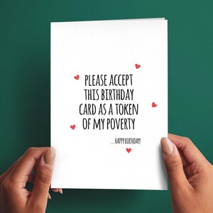 May include: A white rectangular birthday card featuring black text that reads, PLEASE ACCEPT THIS BIRTHDAY CARD AS A TOKEN OF MY POVERTY, followed by smaller text that reads, ...HAPPY BIRTHDAY! The card is decorated with five small red hearts.