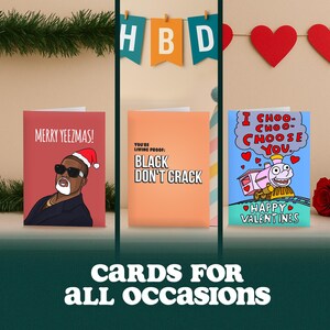K&ouml;nnte beinhalten: Drei Gru&szlig;karten mit unterschiedlichen Designs. Eine Karte zeigt einen Cartoon eines Mannes mit Weihnachtsm&uuml;tze und dem Text "MERRY YEEZMAS!". Eine andere Karte ist orangefarben mit dem Text "YOU'RE LIVING PROOF: BLACK DON'T CRACK". Die letzte Karte hat eine Lokomotive und den Text "I CHOO-CHOO-CHOOSE YOU. HAPPY VALENTINES".