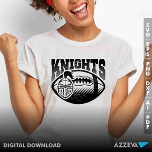 May include: A white t-shirt with a black and white graphic of a football with a knight's helmet and the word "Knights" above it.