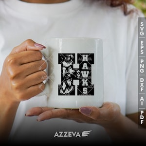 May include: White ceramic mug with a black and white graphic of a hawk's head and the word "HAWKS" spelled out in a unique font.