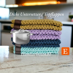 Könnte beinhalten: Ein Stapel von fünf gehäkelten Topflappen in verschiedenen Farben, darunter Senfgelb, Lavendel, Türkis und Blau. Die Topflappen sind dick und haben ein geflochtenes Design. Der Text "Dicke Untersetzer / Topflappen" und "HandarbeitenBF" ist auf den Topflappen sichtbar. Der Buchstabe "E" ist in der unteren rechten Ecke des Bildes sichtbar.