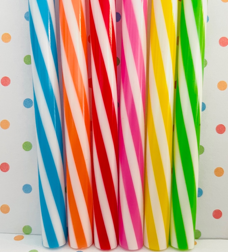 May include: Six striped straws in various colors, including blue, orange, red, pink, yellow, and green. The straws are all white and have a spiral pattern.