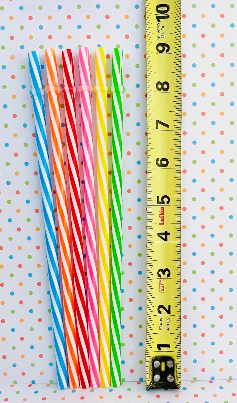 May include: A set of eight striped drinking straws in various colors, including blue, orange, red, pink, yellow, and green. The straws are lined up next to a measuring tape, showing they are approximately 10 inches long.