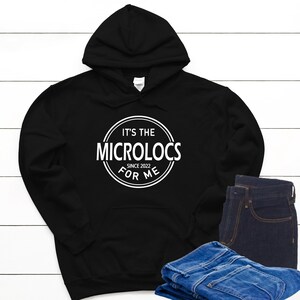 May include: Black hooded sweatshirt with a white circle graphic that says "It's the Microlocs for Me Since 2022".