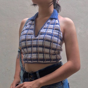 May include: A blue and brown plaid halter top with a v-neck and a crocheted design.