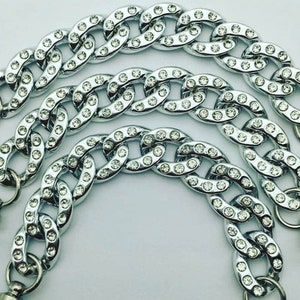 May include: Three silver chains with clear rhinestones. The chains are linked together and have a clasp at the end.