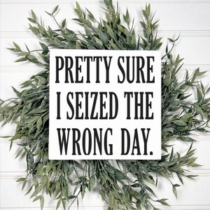 May include: White wooden sign with black text that reads "Pretty sure I seized the wrong day."
