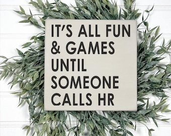 May include: A white wooden sign with black text that reads "It's all fun & games until someone calls HR".