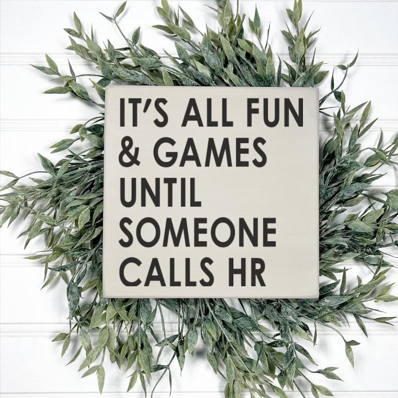 May include: A white wooden sign with black text that reads "It's all fun & games until someone calls HR".