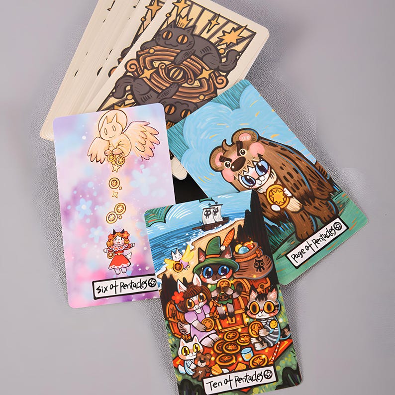 May include: A collection of tarot cards featuring whimsical illustrations. The cards display colorful artwork of animals and figures, including a bear, cats, and an angel. The "Six of Pentacles" and "Ten of Pentacles" cards are visible.