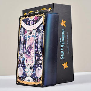 May include: A tarot card deck and box set. The card features a colorful illustration with the text "0. THE FOOL". The box is black with the text "Starry Enigma Tarot" and a yellow flower graphic.