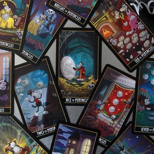 May include: A collection of tarot cards featuring cartoon characters in a spooky theme. The cards have black borders and gold accents, with titles like "Knight of Pentacles" and "Ace of Pentacles". The artwork depicts various scenes with skulls and coins.