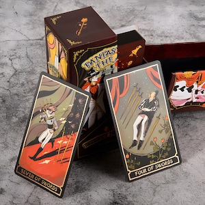 May include: A tarot card deck with a brown box featuring the text "FANTASY THE TAROT". Two tarot cards are visible, one labeled "SEVEN OF SWORDS" and the other "FOUR OF SWORDS". The cards have gold borders and detailed illustrations.