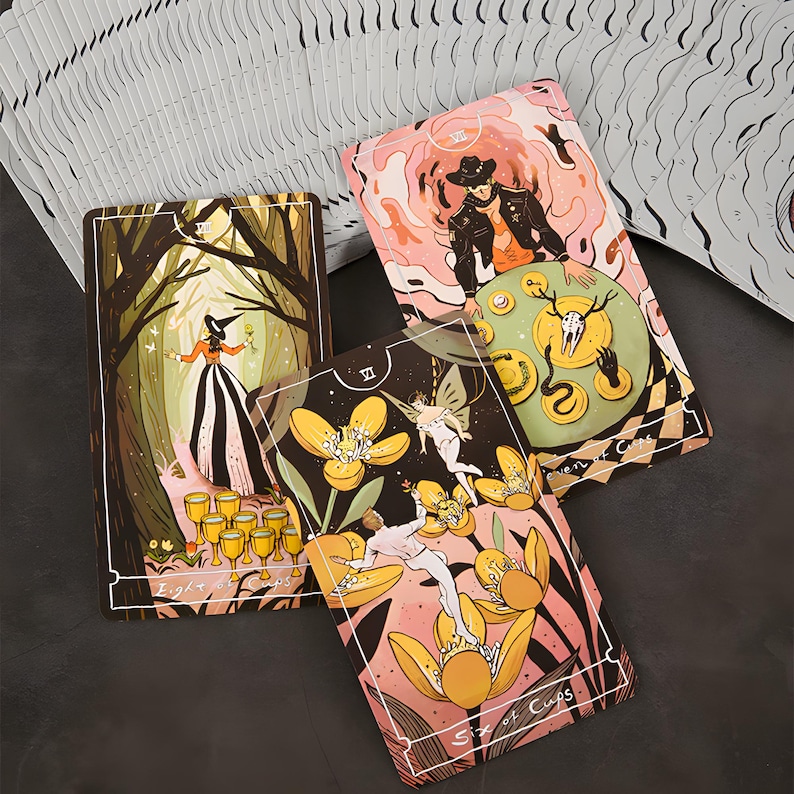 May include: A deck of tarot cards with colorful illustrations. The cards feature images of a witch in a forest, a figure with a hat, and figures with flowers. The cards have white borders and are fanned out.