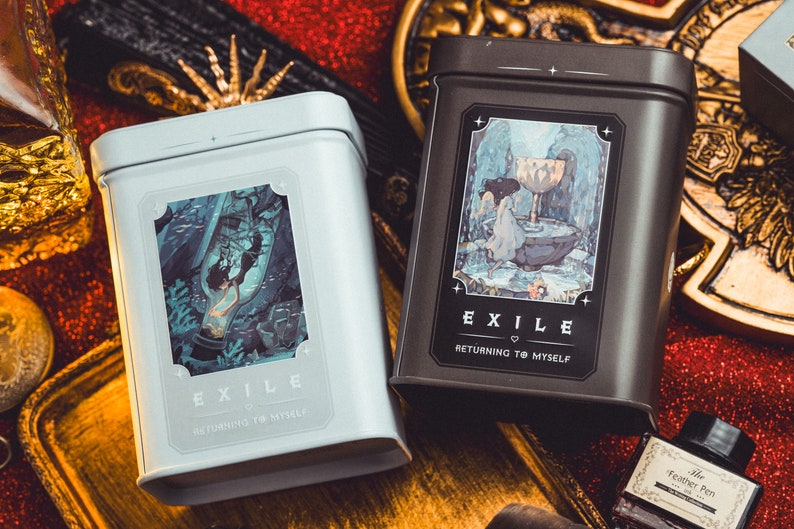 Op de afbeelding: Twee rechthoekige metalen blikken, &eacute;&eacute;n lichtblauw en &eacute;&eacute;n donkergrijs, elk met een decoratief etiket met een illustratie en het woord "EXILE". De tekst "RETURNING TO MYSELF" staat eronder. De blikken staan op een rode glitterondergrond.