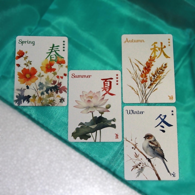 Pu&ograve; includere: Quattro carte rettangolari a tema stagionale. La carta della primavera presenta fiori arancioni, quella dell'estate un loto, quella dell'autunno grano e quella dell'inverno un uccello su un ramo. Ogni carta ha testo in inglese e caratteri asiatici.