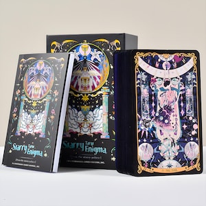 May include: A tarot card deck and guidebook set. The box, book, and cards feature a dark background with colorful illustrations of celestial and mystical themes. The text "Starry Enigma" is visible on the box and book. The card deck shows "O The Fool".