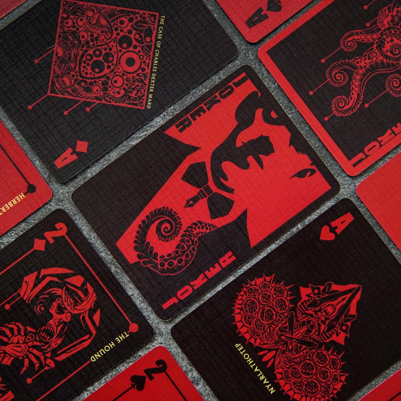 Puede incluir: Un juego de cartas con un esquema de color negro y rojo. Las cartas presentan ilustraciones de criaturas y el texto "JOKER" y "THE CASE OF CHARLES DEXTER WARD".