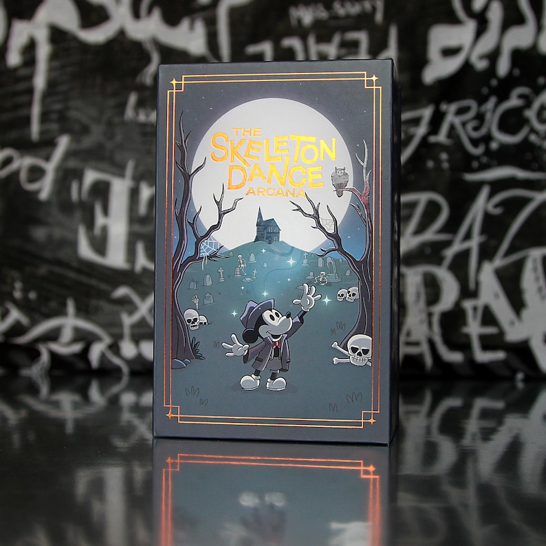 May include: A rectangular box featuring a spooky illustration with the text "THE SKELETON DANCE ARCANA." The artwork depicts a cartoon mouse character in a graveyard scene with a full moon, trees, and skulls. The box has gold trim.