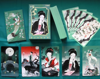 May include: A tarot card deck featuring a green box with a woman illustration and the text Life is but a dream. The set includes a guidebook and multiple cards displaying traditional ink-style artwork of figures, landscapes, and nature scenes in muted tones.