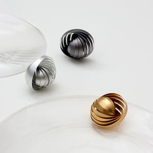 Può includere: Un set di tre tazze in ceramica con finitura opaca e macchiettata. Le tazze sono nei toni del crema, marrone chiaro e marrone scuro. Ogni tazza ha un design semplice e minimalista.