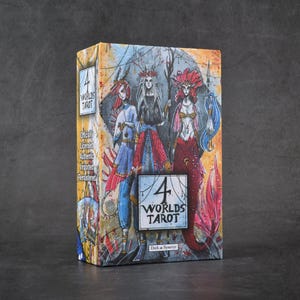 Puede incluir: Una caja de cartas del tarot con una colorida ilustración de tres figuras místicas. La caja está etiquetada como "4 Worlds Tarot" con texto adicional que indica que es oficial, con licencia y remasterizada.