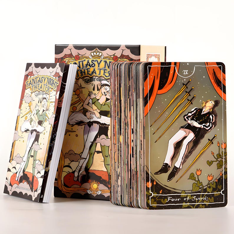 May include: A tarot card deck with a fantasy theme. The deck includes a box, a guidebook, and a deck of cards. The cards feature illustrations of ballet dancers and other theatrical figures. The "Four of Swords" card is visible, with a figure lying down.