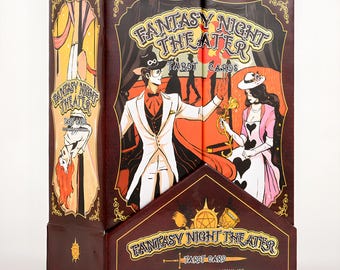 May include: A tarot card box with the words "Fantasy Night Theater" in gold lettering. The box features illustrations of a magician and a woman in a pink dress. The box is brown with gold accents and a display stand.