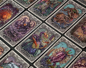 May include: A set of playing cards featuring illustrations of various creatures and monsters. The cards have a silver border and a black and white background. The card names include "K'thun", "Tawil-at-Umr", "Lloigor & Zhar", "Yog-Sothoth", "Great Race of Yith", and "Eld".