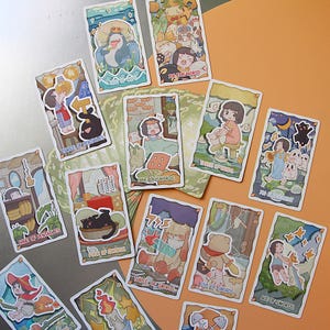 May include: A collection of tarot cards with whimsical illustrations. Each card features a unique design with characters and symbols, including the "King of Cups," "Three of Pentacles," and "Nine of Swords." The cards are arranged on an orange surface.
