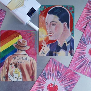 May include: A collection of illustrated cards featuring a person in a tuxedo lighting a cigarette, a person in a trench coat with the text NO ONE LIKE YOU, and cards with red cherries on a pink starburst background, alongside a pack of cigarettes.