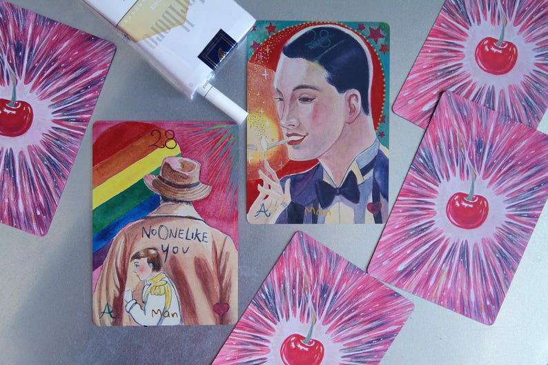May include: A collection of illustrated cards featuring a person in a tuxedo lighting a cigarette, a person in a trench coat with the text NO ONE LIKE YOU, and cards with red cherries on a pink starburst background, alongside a pack of cigarettes.