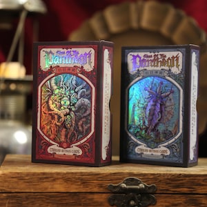 May include: Two rectangular card game boxes titled Call of the Pantheon Cthulhu Mythos Cards. The left box is red with a holographic illustration of a multi-eyed creature. The right box is blue with a holographic illustration of a winged figure.