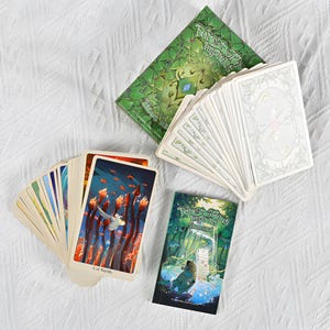 May include: A tarot card deck with a green box and a small booklet. The cards feature colorful illustrations, including one labeled "8 of Wands." The box and booklet have the text "Forest Spirit Imprints."