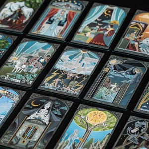 May include: A collection of rectangular tarot cards arranged in a grid, each featuring detailed, colourful illustrations with dark borders. The cards display various scenes including figures, celestial bodies, architectural elements, and symbolic motifs.