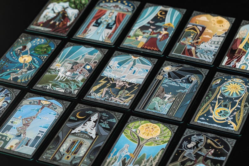 May include: A collection of rectangular tarot cards arranged in a grid, each featuring detailed, colourful illustrations with dark borders. The cards display various scenes including figures, celestial bodies, architectural elements, and symbolic motifs.