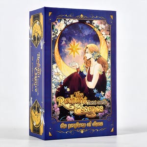 Puede incluir: Caja de cartas del tarot con fondo azul oscuro y detalles dorados. La caja presenta una ilustraci&oacute;n de una mujer en una luna creciente, con el texto "The Radiant Essence tarot cards" y "the prophecy of chaos".