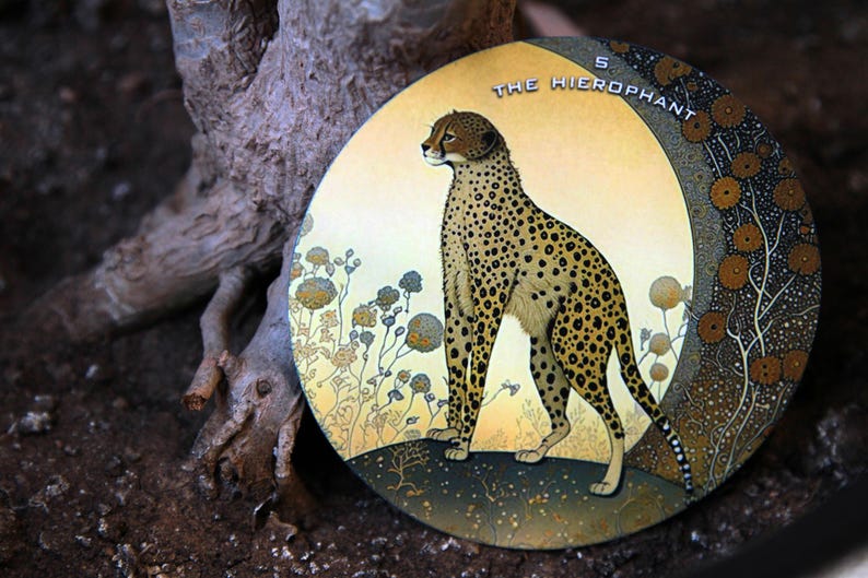 May include: Circular artwork featuring a cheetah with a spotted coat, set against a yellow and green background. The text "THE HIEROPHANT" and the number "5" are visible. The artwork is surrounded by stylized floral elements.