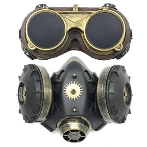 May include: A steampunk-style gas mask with a black and gold design. The mask has two large round filters on the sides and a smaller filter in the front. The mask is attached to a pair of goggles with round lenses.